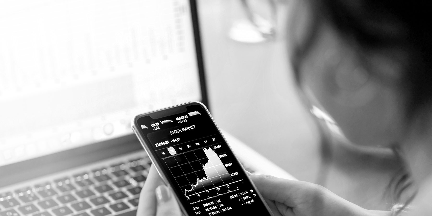 A woman looking at a stock performance chart on her mobile phone